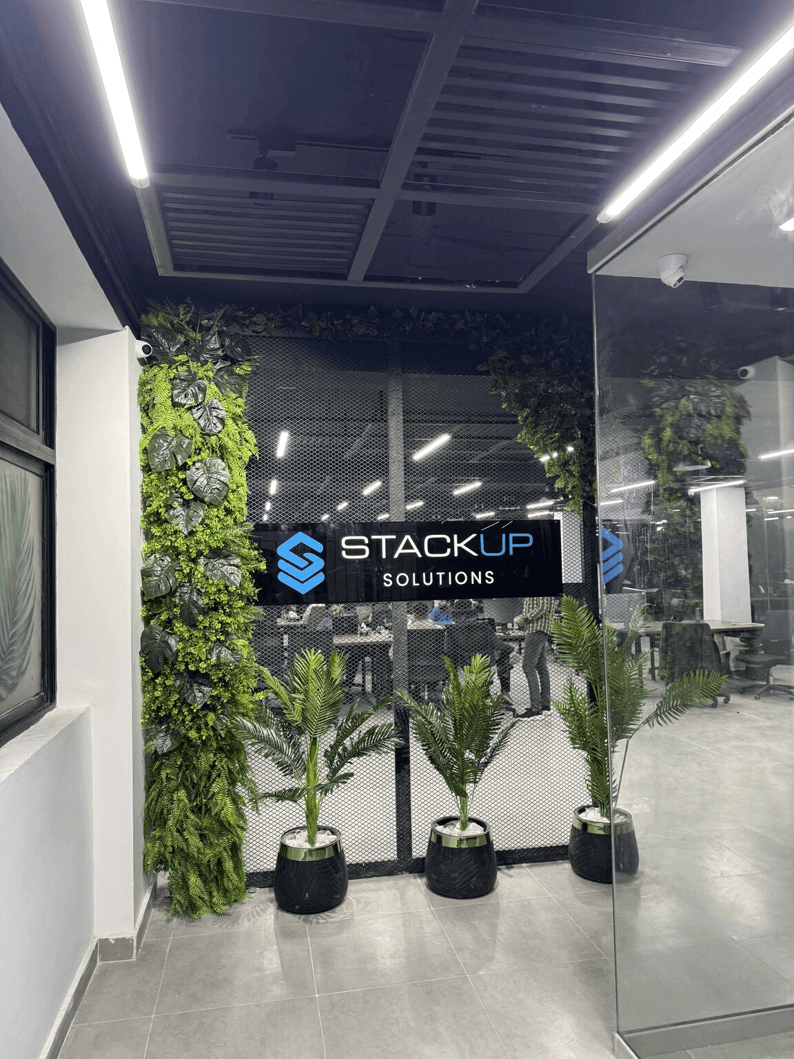 Entrance to Stackup Solutions office with green wall and modern decor.